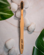 Eco-friendly bamboo charcoal toothbrush with biodegradable handle and soft charcoal bristles for sustainable oral care.