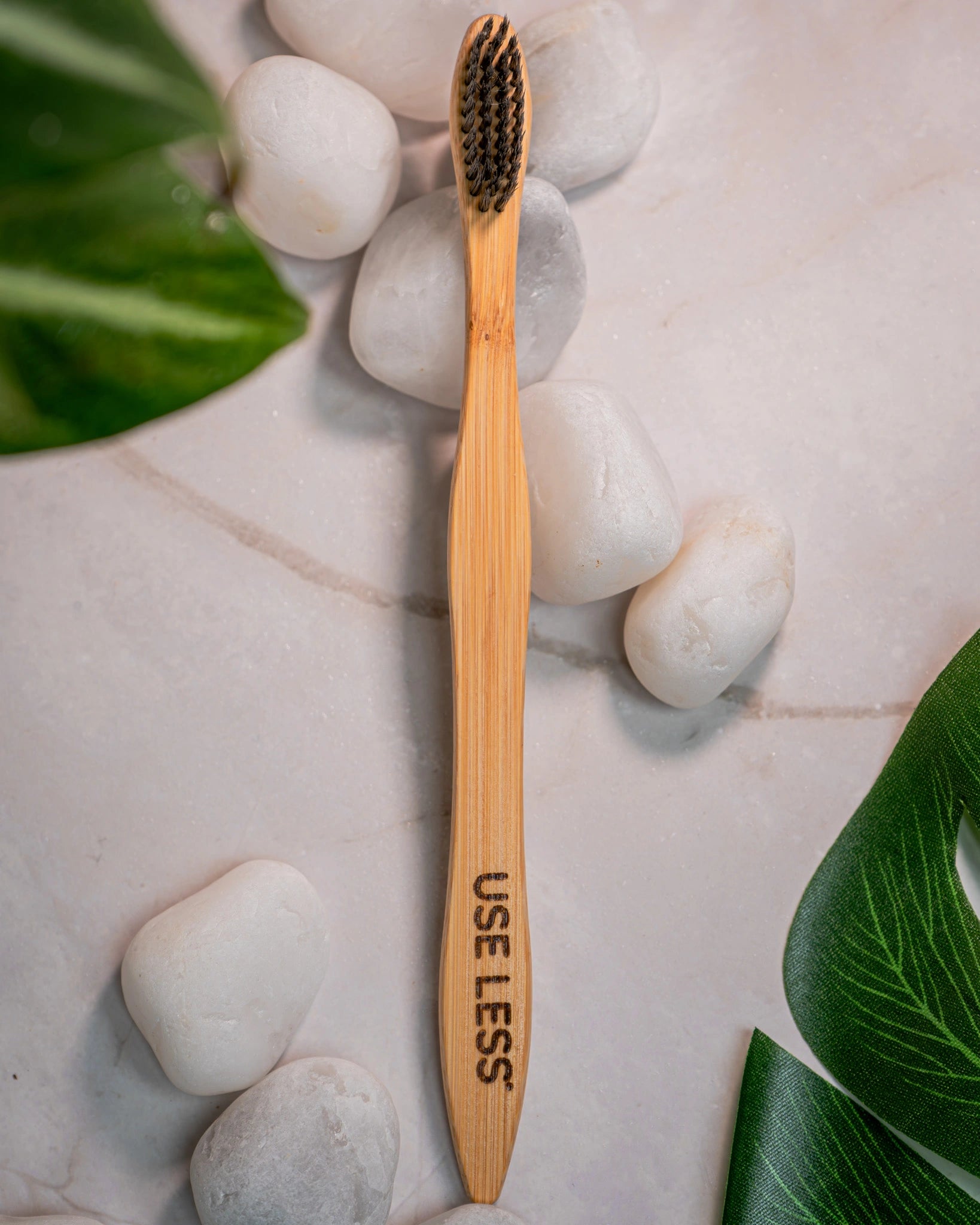 Eco-friendly bamboo charcoal toothbrush with biodegradable handle and soft charcoal bristles for sustainable oral care.